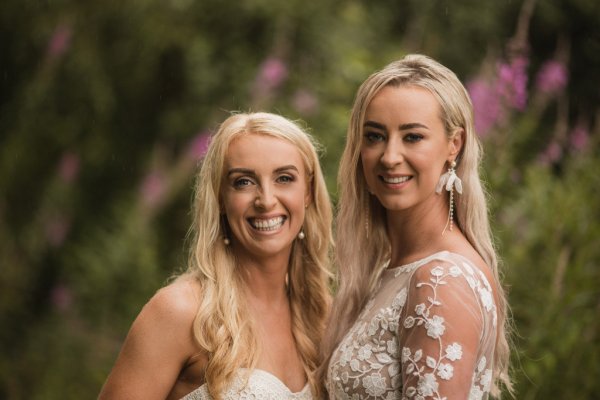 Bride and bride couple holding hands in forest