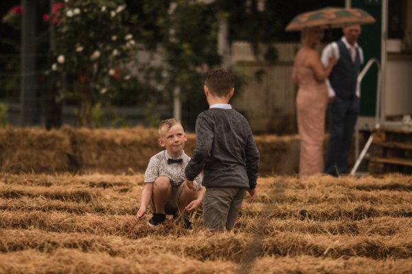 Little boys jumping on hay playing