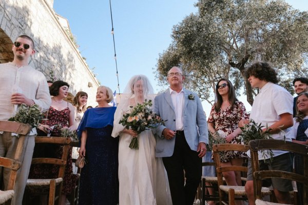 Father of the bride walks down the aisle towards groom