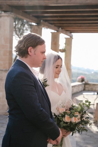 Bride and groom at alter holding bouquet of flowers