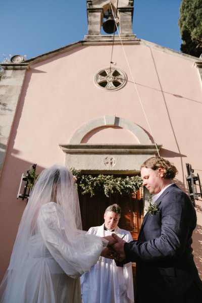 Groom and bride at alter with priest church setting