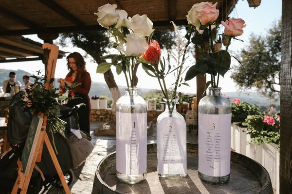 Bottles with flowers inside holders on table