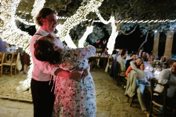 Bride and groom dance on the dancefloor lights in background