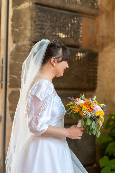 Bride holding colourful bouquet of flowers smiling