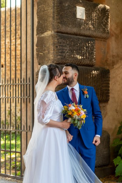 Bride and groom kiss kissing at gate