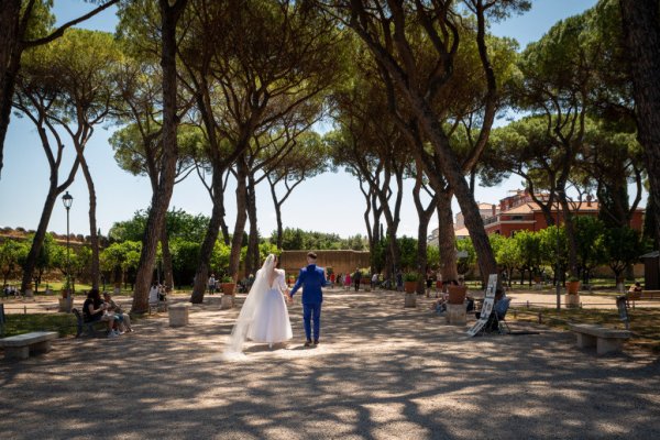 Bride and groom hand in hand holding hands in park