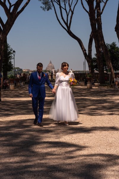 Bride and groom hand in hand holding hands in park