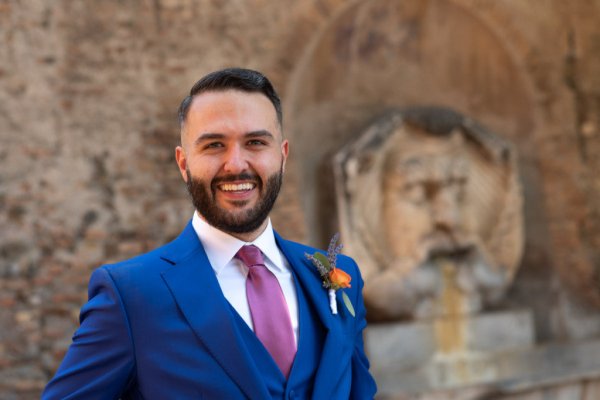 Groom in front of Roman statue fountain myth God