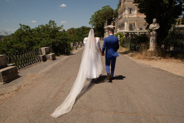 Bride and groom from behind walk together hand in hand