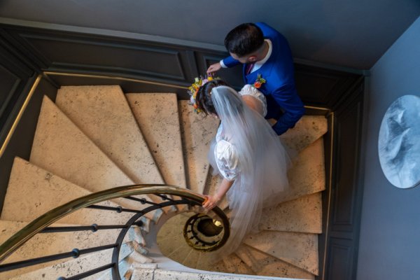 Bride and groom walk up the winding staircase stairs