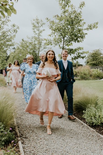 Bridesmaid and family walk pathway