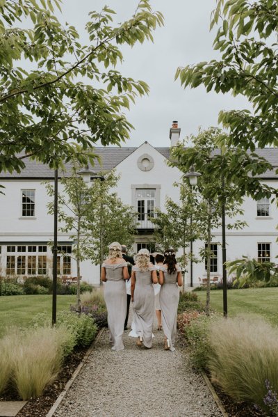 Bridesmaids walk towards wedding venue