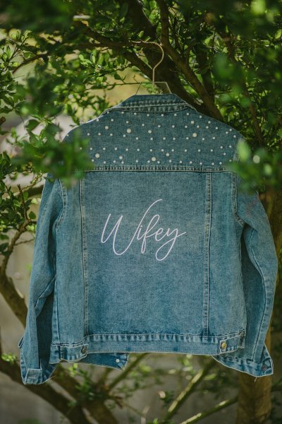 Wifey denim jacket hanging in garden