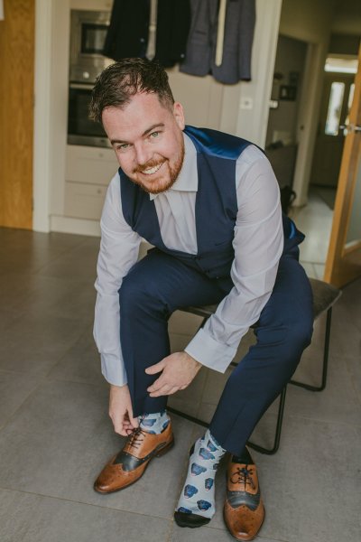 Groom putting on wedding brogue shoes