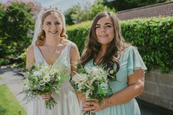 Bride and bridesmaid exterior shot bouquet flowers