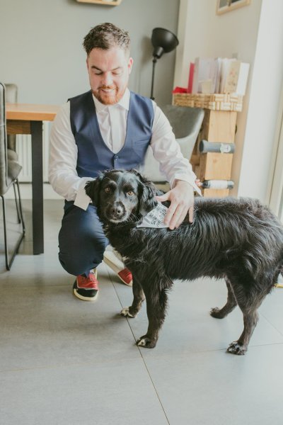 Groom and black dog play