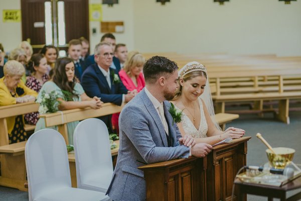 Bride and groom sitting on pew at alter