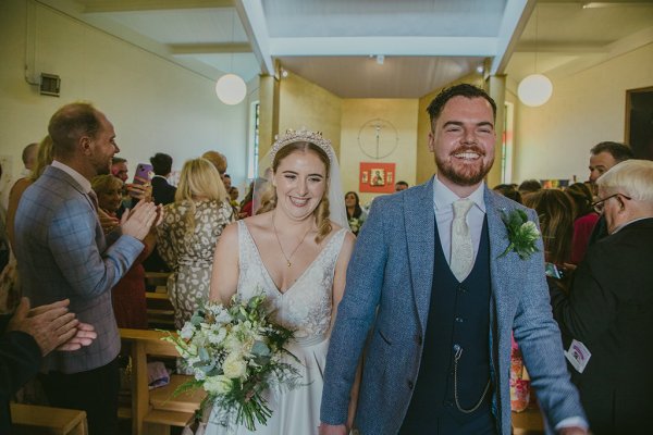 Bride and groom at church alter just wed holding hands smiling