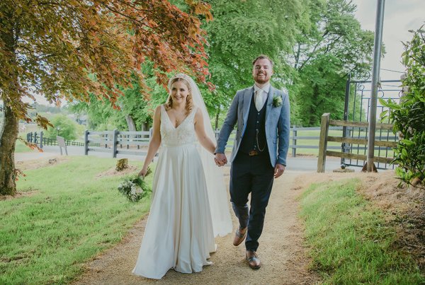 Bride and groom walk pathway of forest