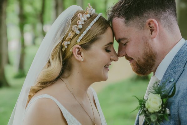 Couple touch foreheads bride and groom park