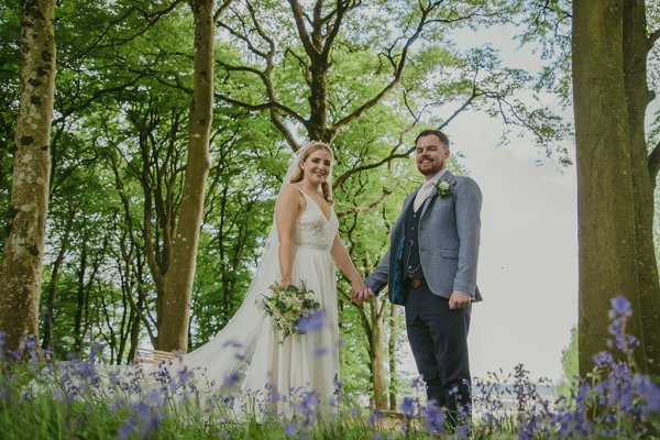 Bride and groom walking through park hand in hand tulips trees