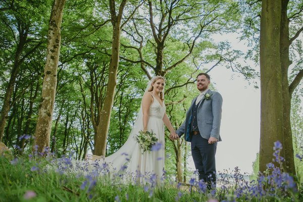 Bride and groom walking through park hand in hand tulips trees