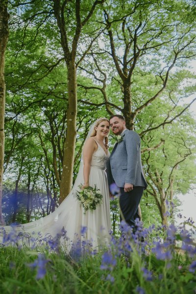 Bride and groom walking through park hand in hand tulips trees