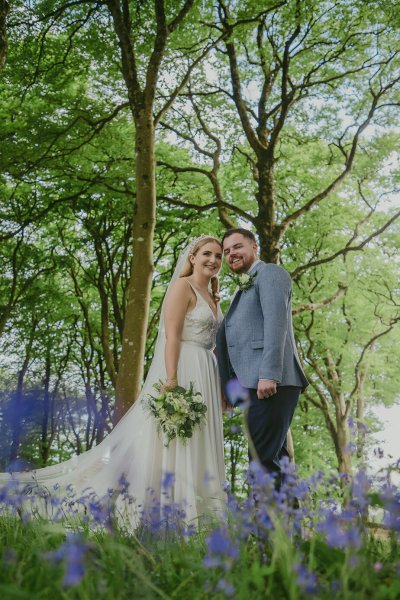 Bride and groom walking through park hand in hand tulips trees