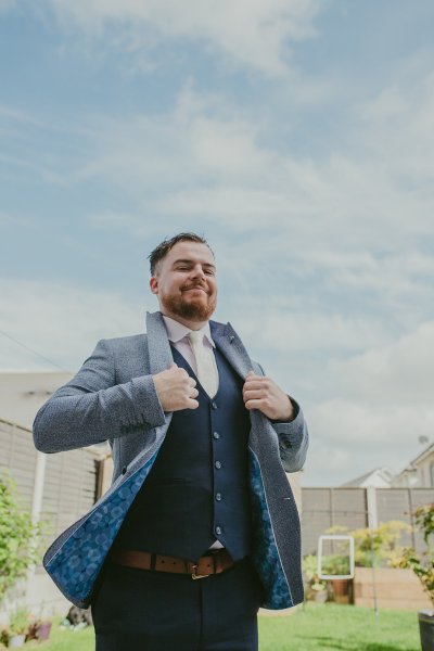 Groom fixing suit outside