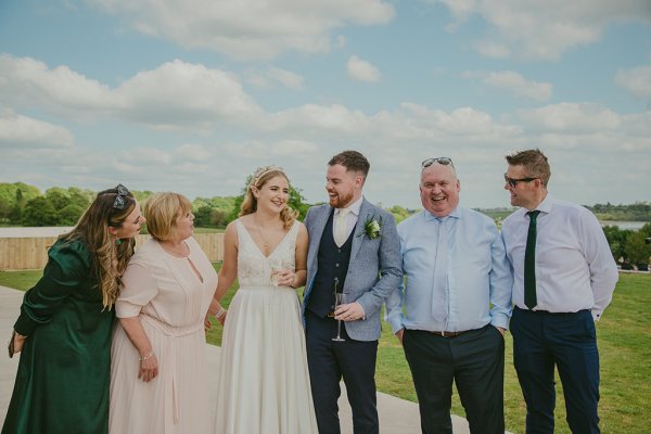 Bride groom father and mother drinking champagne smiling