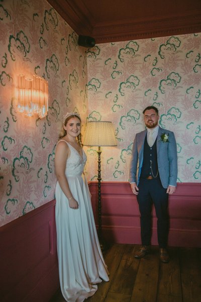 Bride and groom stand interior room pink decor