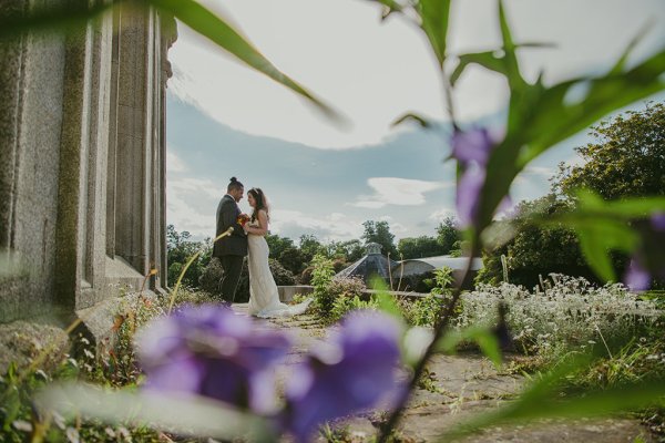 Purple flowers in foreground couple bride and groom in background