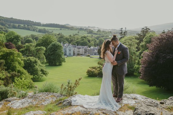 Killruddery house wedding venue in background bride and groom stand on grass face each other