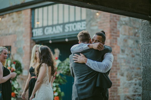 Groom hugs man/friend or guest