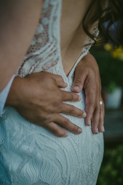 Grooms hand on brides back ring detail