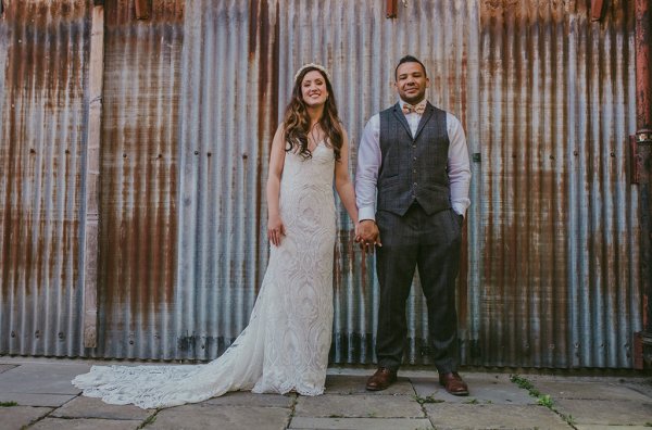 Bride and groom stand in front of door