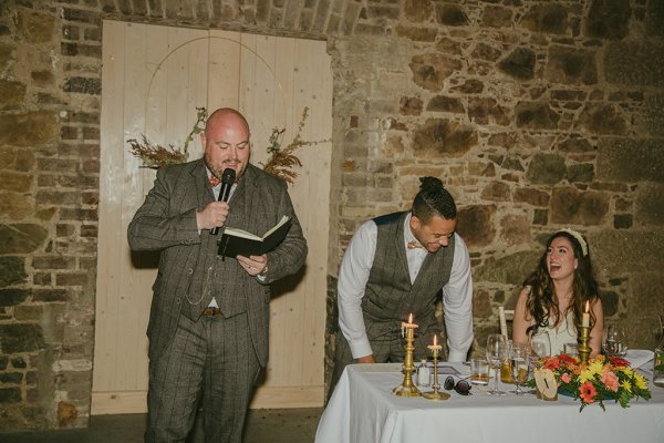 Man reading from book during speech and groom