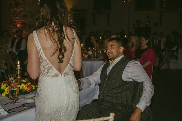 Groom seated with bride from behind