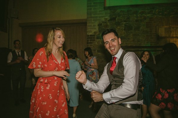 Woman in orange dances with man