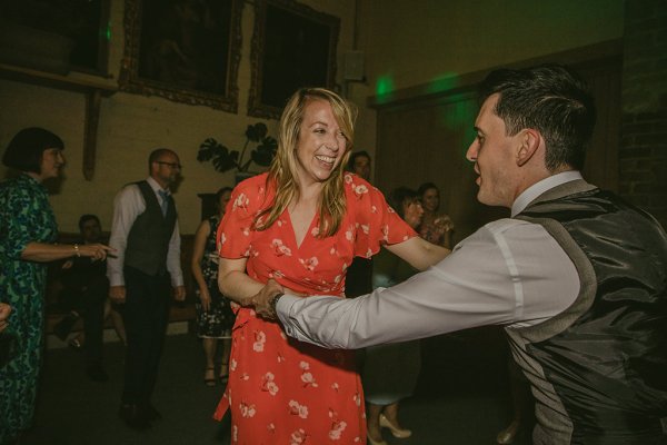 Woman in orange dances with man