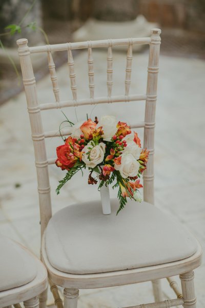 Bouquet of flowers orange and red sitting on chair