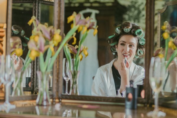 Yellow sunflowers and bride wearing curlers in hair lipstick