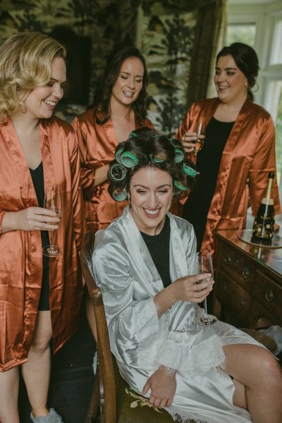 Orange satin bridalwear bridesmaids cheers champagne and bride