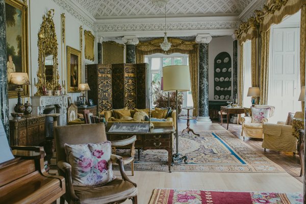 Empty manor dining room portraits carpet chair and bookshelf