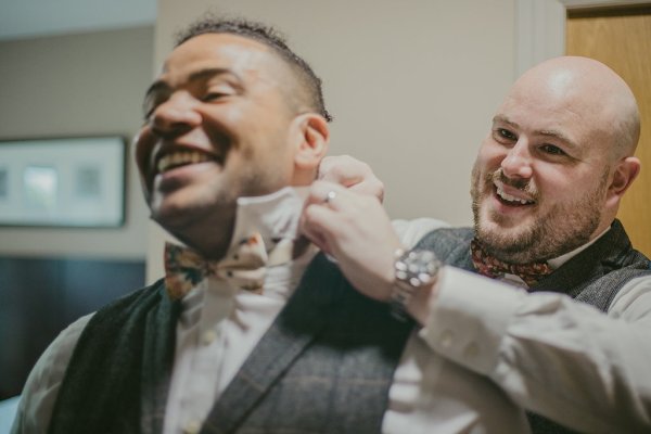 Groom with suit on getting ready with groomsman