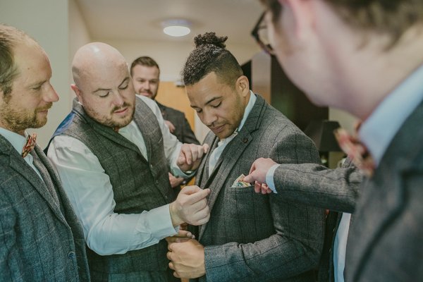 Groom with suit on getting ready with groomsmen watch detail