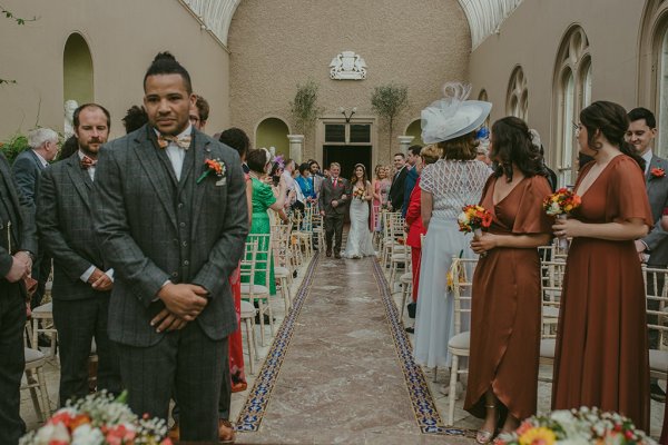 Father of the bride walks down the aisle guests groom