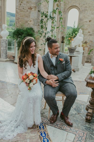 Bride and groom flowers orange roses bouquet sitting holding hands