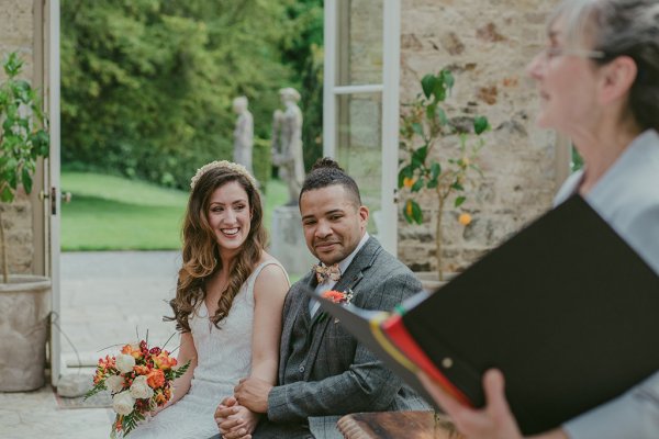 Bride and groom flowers orange roses bouquet sitting holding hands