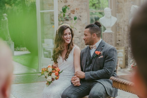 Bride and groom flowers orange roses bouquet sitting holding hands